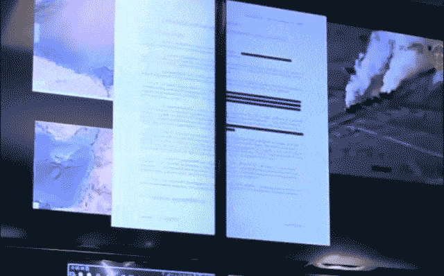 An animated GIF: a single document is displayed across two screens of notionally different classifications. As the document moves from one display to another, redactions within the document appear and disappear commensurate with the classification of the display.